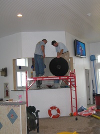 Al and Jason hanging the clock next to the BIG SCREEN TV
